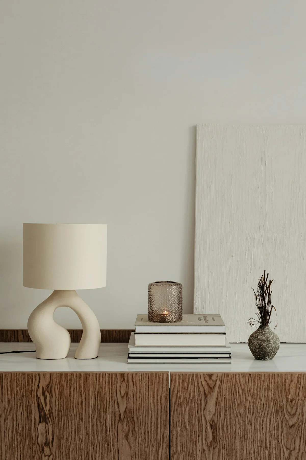 Lampe, livres et objets décoratifs sur un meuble, image d’inspiration